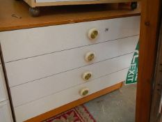 A white four drawer chest.