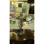 A three light table lamp with Tiffany style shades.