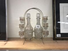 A retro 2 bottle tantalus with 6 glasses