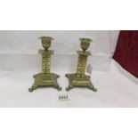 A pair of 19th century brass candlesticks on square footed bases with cubed columns.