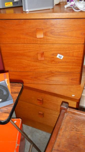 A pair of teak bedside cabinets.