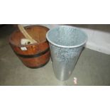 A coopered log bucket and a metal flower vase.