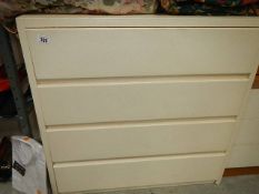 A white four drawer chest.