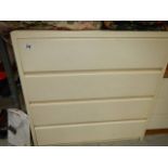 A white four drawer chest.