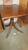 A mahogany drop side table on brass lion paw feet.