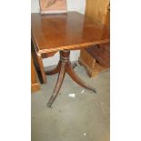 A mahogany drop side table on brass lion paw feet.