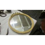 A circular gilt framed bevel edged mirror.