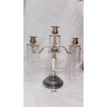 A silver plate candelabra with crystal droppers.