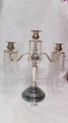 A silver plate candelabra with crystal droppers.