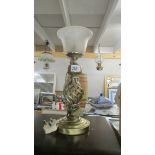 A metal table lamp with glass shade.