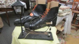 A massive pair of oversized boots and a table lamp featuring a street lamp and a penny farthing