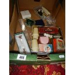 A box of miscellaneous items including Avon jewellery items, badges, harmonica etc.