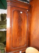 A flamed mahogany corner cupboard.