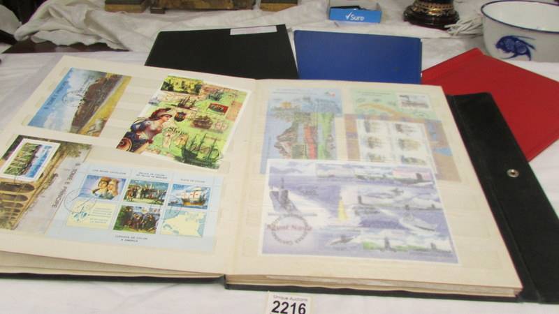 Four folders of assorted world stamps.