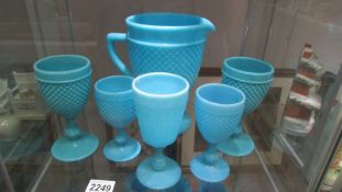 A blue glass jug and five goblets.