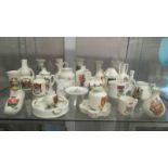 In excess of 60 pieces of crested china, various makers and locations, (3 shelves).
