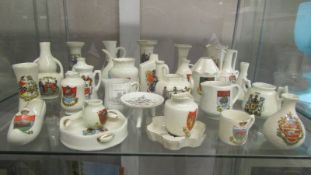 In excess of 60 pieces of crested china, various makers and locations, (3 shelves).