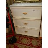 A white three drawer chest.