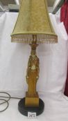 An art deco style figural table lamp with shade.