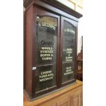 A sign written haberdashery cabinet.