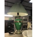 A green and gilded table lamp with shade