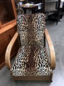 A 1930's oak framed armchair with later leopard print upholstery