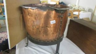 A copper cauldron on metal stand.