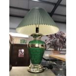A green and gilded table lamp with shade