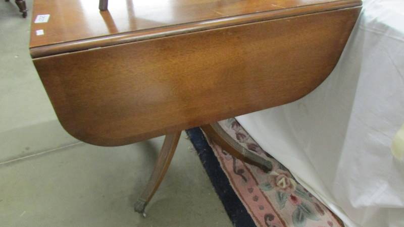 A mahogany drop side table on brass lion paw feet. (Collect only). - Image 2 of 2