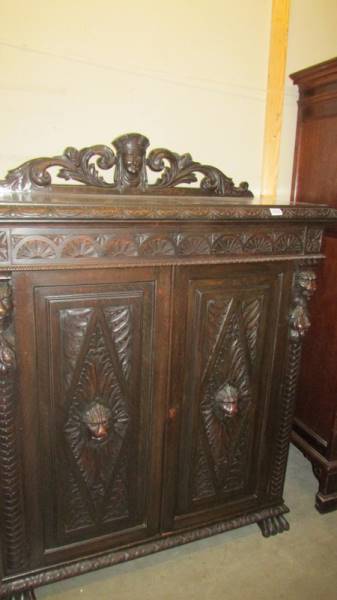 A large continental carved oak cupboard with ebony trim. (Collect only).