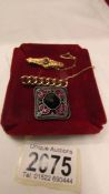 A 15ct gold brooch set with a garnet, another yellow metal brooch and a stone set brooch.