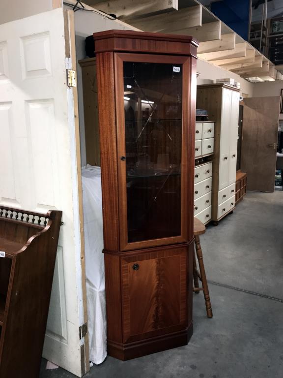 A light mahogany effect corner cupboard