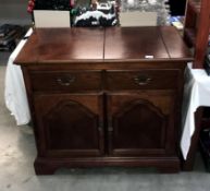 A dark wood stained drinks cabinet