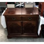 A dark wood stained drinks cabinet