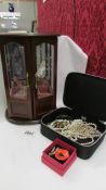 A jewellery cabinet with necklaces and a jewellery box with costume jewellery.