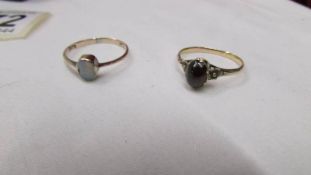 Two 19th century rings, one set with a cabachon garnet with textured flower heads to shoulders,