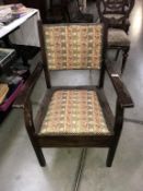 An Edwardian mahogany commode armchair with tapestry paneled seat & back