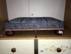 A tapestry covered foot stool