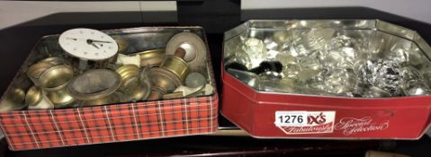 A quantity of glass decanter stoppers and a tin of brass including oil lamp parts