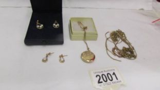 Approximately 10 grams of scrap gold, a gold plated locket on chain and 2 pairs of earrings.