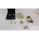 Approximately 10 grams of scrap gold, a gold plated locket on chain and 2 pairs of earrings.