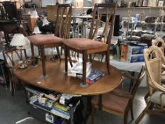 An extending teak dining table and 6 chairs