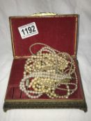 A jewellery box containing pearl necklaces