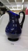 A large Bristol blue glass jug with stapled repair.