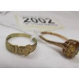 A 9ct gold buckle ring, size O, 1.8 grams and a 9ct gold ring set yellow stone, size P.