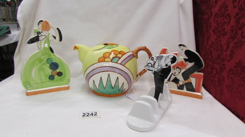 An abstract design tea set, two 1920's style figures and a Butler toast rack.