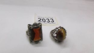 A silver ring set Tiger's eye and another silver ring set amber coloured stone.