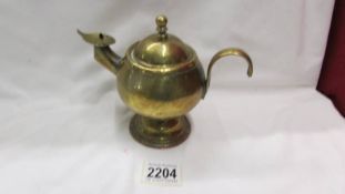 A vintage brass whale oil lamp in the for of a kettle/aladdin lamp.