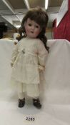 A Victorian porcelain doll with replacement wig, Made in Germany, Walsch.