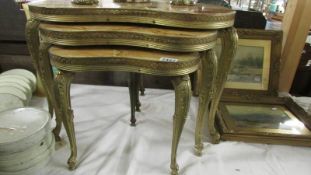 A nest of three kidney shaped tables with marble tops.